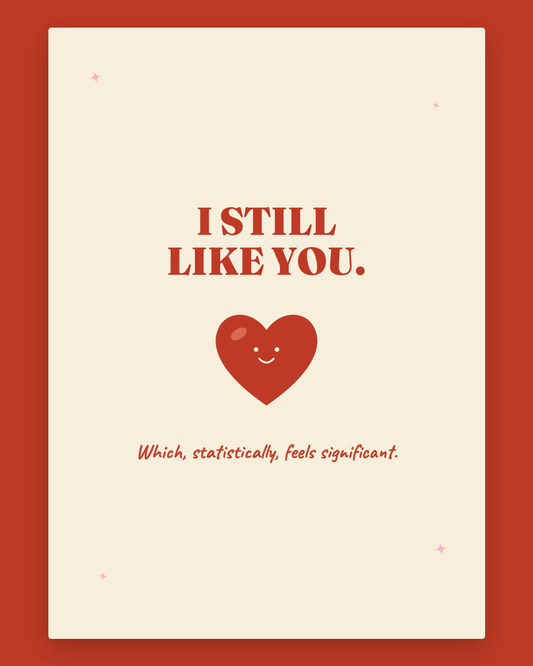I Still Like You greeting card — cream card with cherry red lettering and a smiling heart